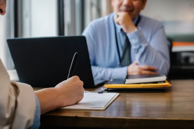 Crop anonymous female filling questionnaire when applying for job sitting in employer office. Rättssäker rekrytering: från behov till anställning